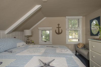 King room with nautical bedspread and decor overlooks teh gardens of the Ships Knees Inn