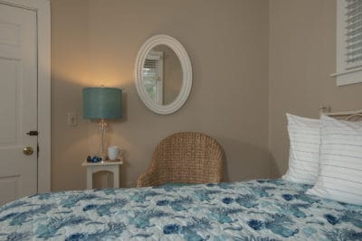 oval mirror and bedside lamp decorate the wall of the queen room #10