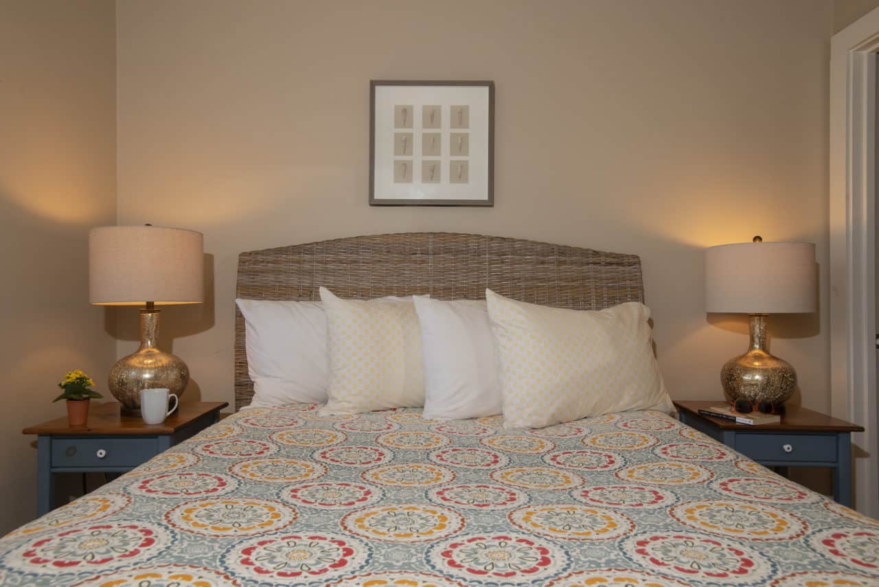 A queen bed with several plush pillows