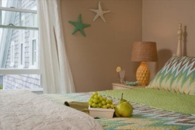Deluxe room 9 with fruit on bed and coastal starfish wall decor