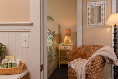 View into queen bedroom 9 with wicker chair