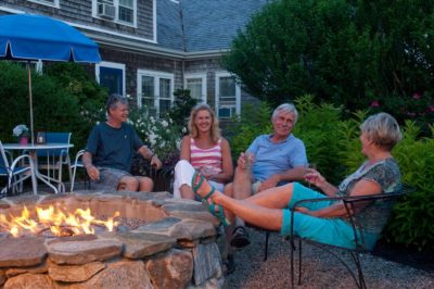 Guests lounge in the evening at our firepit and enjoy a glass of wine