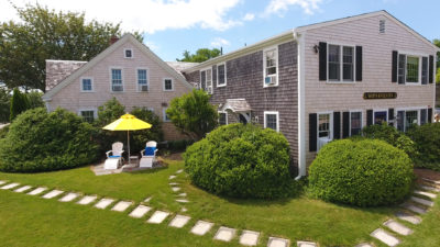 Entrance to the Ships Knees Inn with adirondack chairs and umbrella