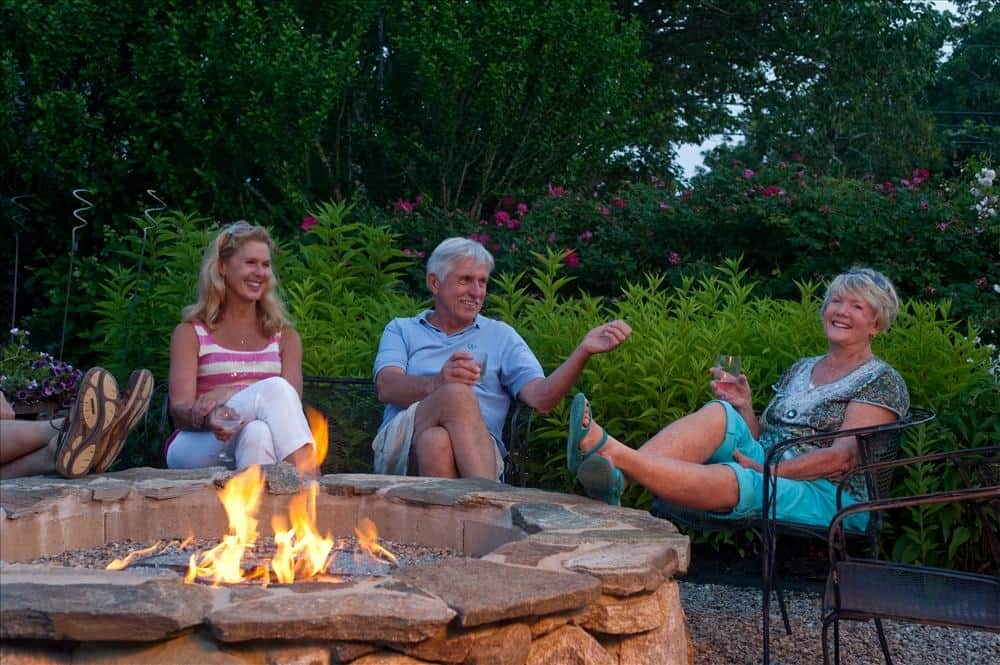 2 couples enjoying conversation by the fire pit