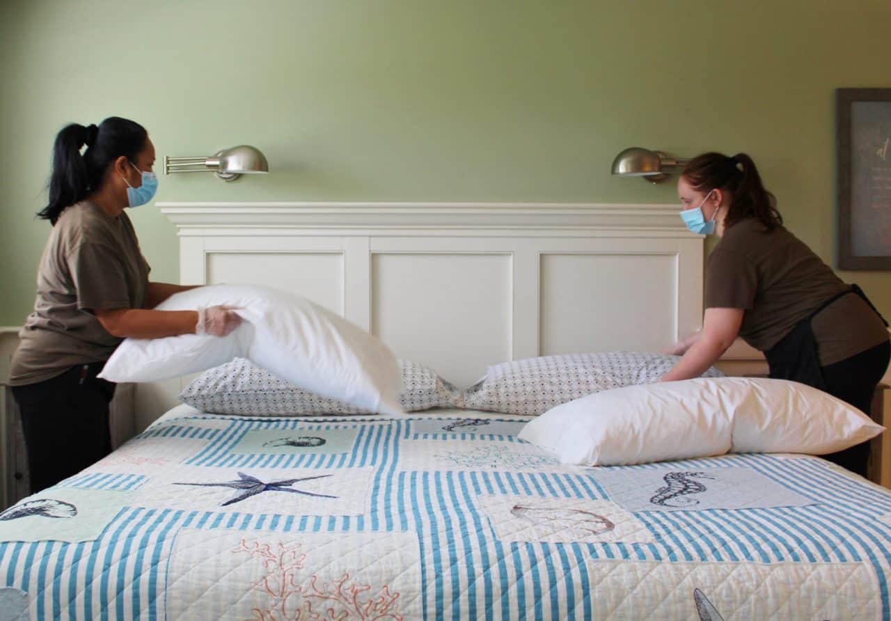 Masked housekeepers prepare the beds in the Ships Knees Inn