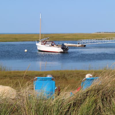 A couple sit by the wtaer in Nauset Marsh