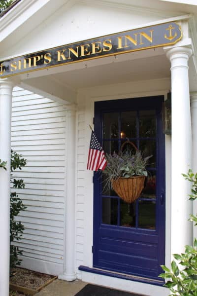 The office door at the Ships Knees Inn with sign and USA flag